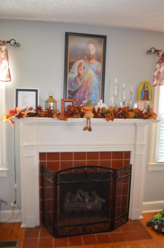 room details featuring a textured ceiling and a tile fireplace