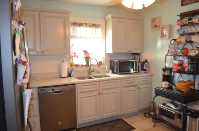 kitchen with tasteful backsplash, sink, light tile patterned floors, and stainless steel appliances