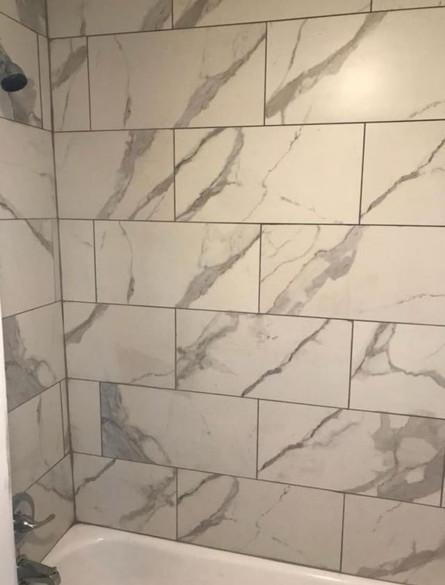 interior space with tiled shower / bath combo