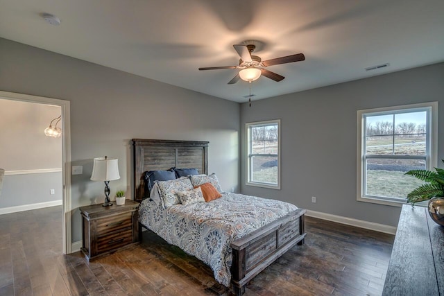 bedroom with multiple windows, ceiling fan, and dark wood-type flooring