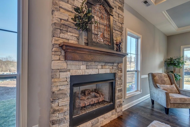 sitting room featuring a stone fireplace and dark hardwood / wood-style flooring