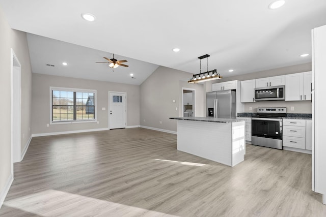 kitchen with white cabinetry, a center island, ceiling fan, stainless steel appliances, and lofted ceiling