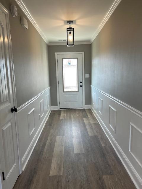 doorway to outside with dark hardwood / wood-style floors and crown molding