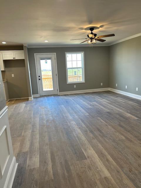 spare room with dark hardwood / wood-style flooring, ceiling fan, and ornamental molding