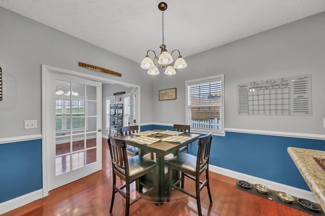 dining room featuring a chandelier, hardwood / wood-style floors, and a textured ceiling