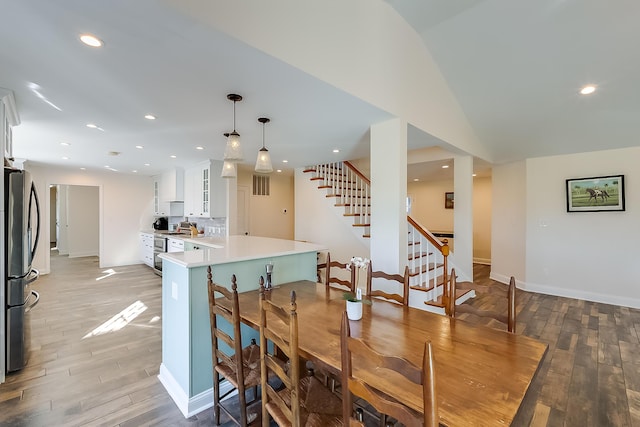 dining space with light wood-type flooring and vaulted ceiling