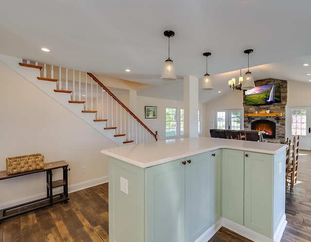 kitchen with a fireplace, pendant lighting, a kitchen island, and a wealth of natural light