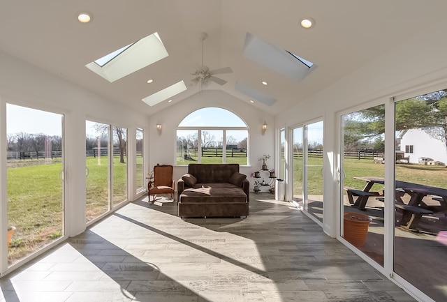 sunroom / solarium with lofted ceiling with skylight and ceiling fan