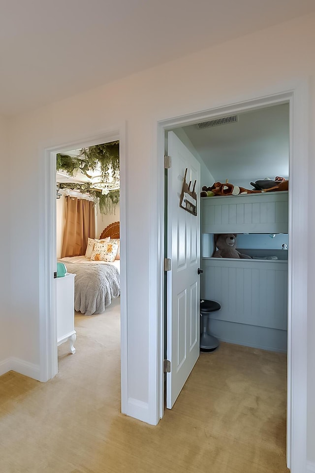 hallway featuring light colored carpet