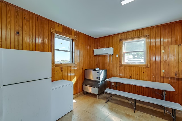 misc room with wooden walls, a wall unit AC, and a healthy amount of sunlight