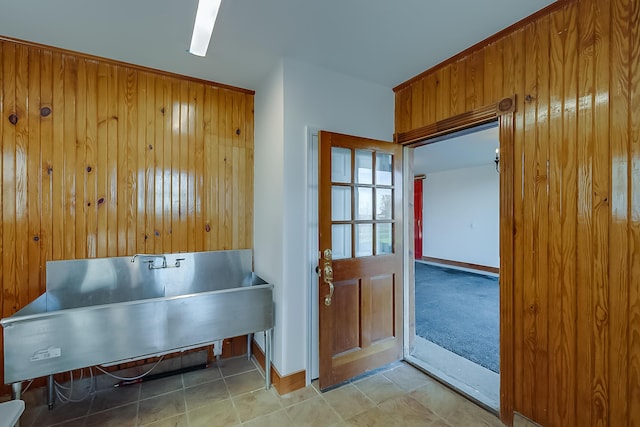 misc room featuring wood walls and sink