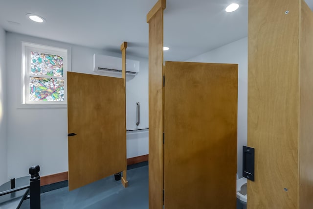 bathroom featuring a wall mounted air conditioner and concrete floors