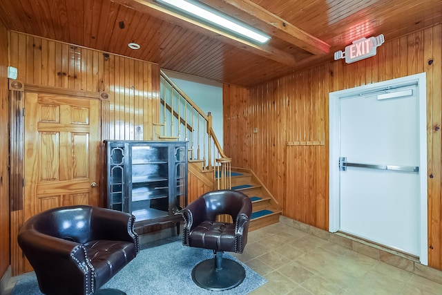 sitting room with beamed ceiling, wood walls, and wood ceiling