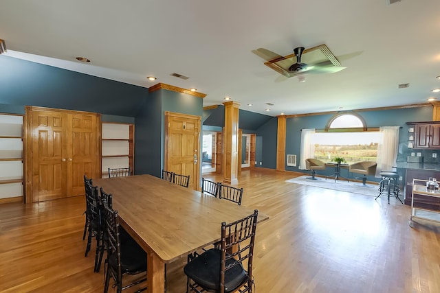 dining area featuring ceiling fan, light wood-type flooring, ornamental molding, and decorative columns