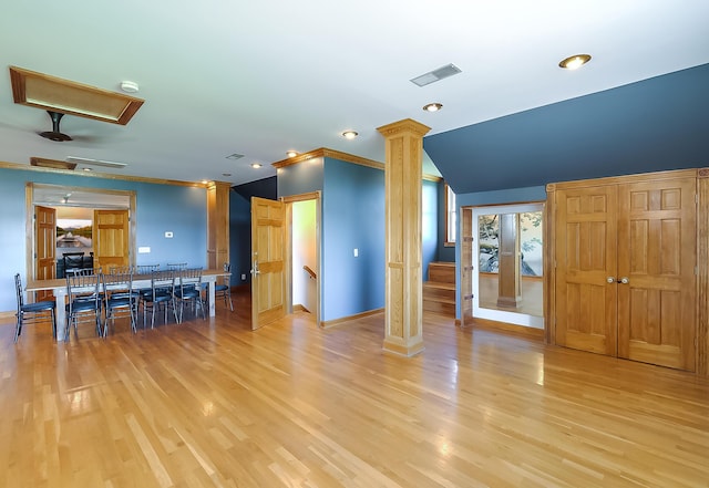 unfurnished living room with decorative columns, light hardwood / wood-style flooring, and ornamental molding