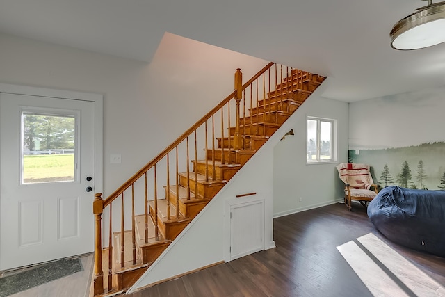 stairway featuring a wealth of natural light and hardwood / wood-style floors