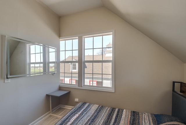 bedroom featuring wood-type flooring and vaulted ceiling