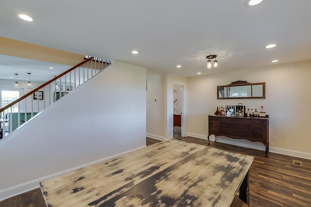 interior space with bar and dark wood-type flooring