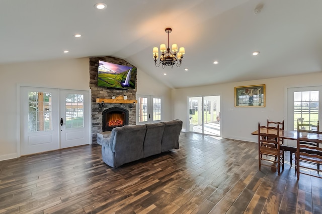 living room with a stone fireplace, plenty of natural light, lofted ceiling, and an inviting chandelier