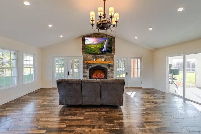 living room with a notable chandelier, lofted ceiling, and a fireplace