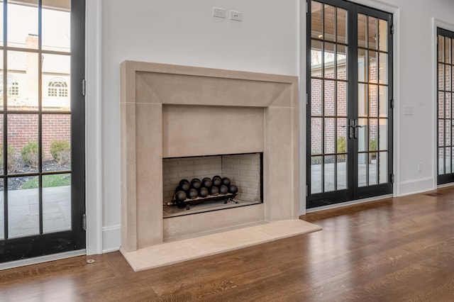 room details with hardwood / wood-style floors, french doors, and a premium fireplace