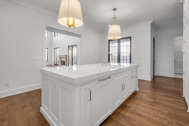 kitchen with sink, dark wood-type flooring, an island with sink, decorative light fixtures, and white cabinets