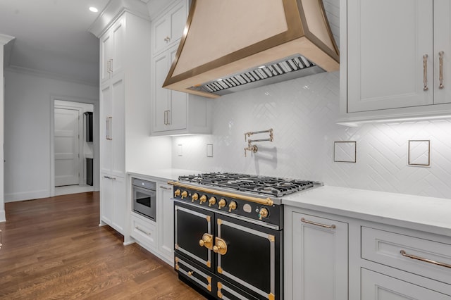 kitchen with white cabinets, custom range hood, backsplash, and double oven range