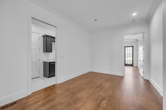 unfurnished room with wood-type flooring and ornamental molding