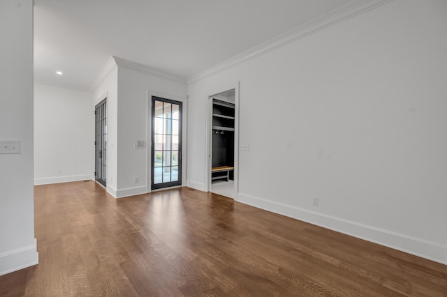 spare room with wood-type flooring and ornamental molding