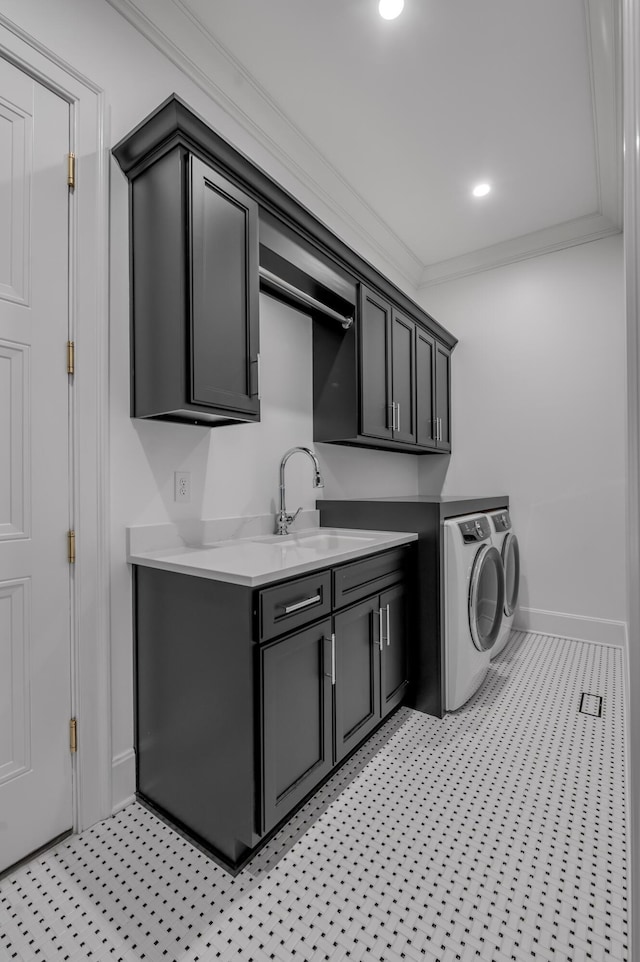 clothes washing area featuring washing machine and clothes dryer, sink, cabinets, and ornamental molding