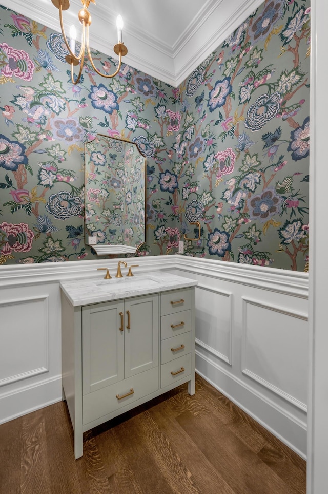 bathroom with vanity, hardwood / wood-style flooring, ornamental molding, and a notable chandelier