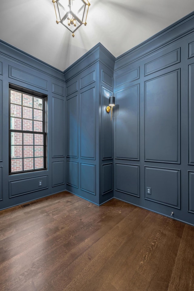 spare room featuring dark hardwood / wood-style floors and an inviting chandelier