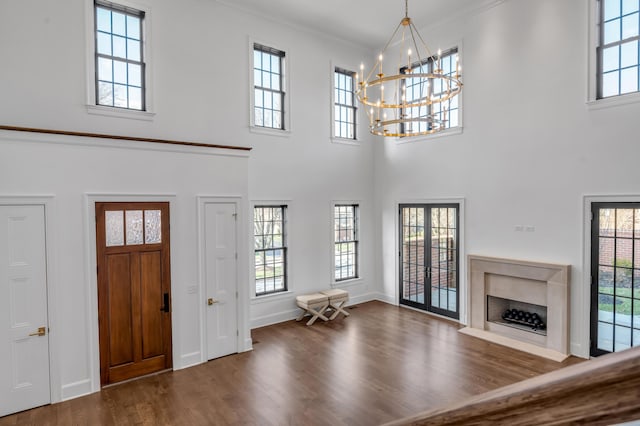 entrance foyer featuring a towering ceiling, a healthy amount of sunlight, and a premium fireplace