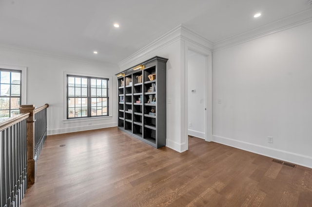 unfurnished room featuring crown molding, plenty of natural light, and dark hardwood / wood-style floors