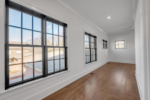 unfurnished room with ceiling fan, dark hardwood / wood-style flooring, and crown molding