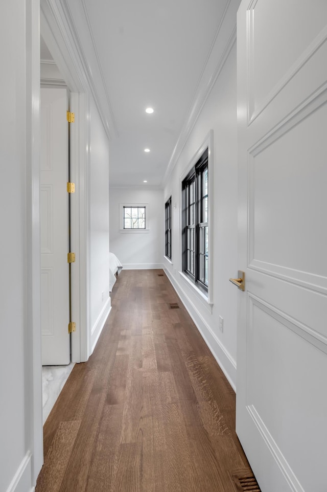 hallway with hardwood / wood-style flooring and ornamental molding