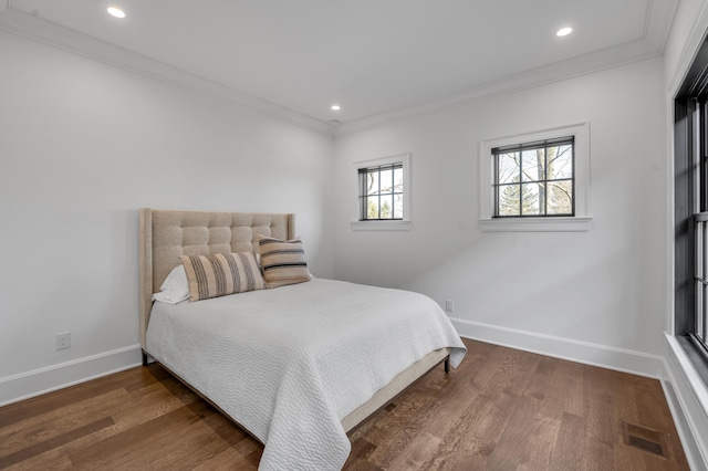 bedroom with crown molding and dark wood-type flooring