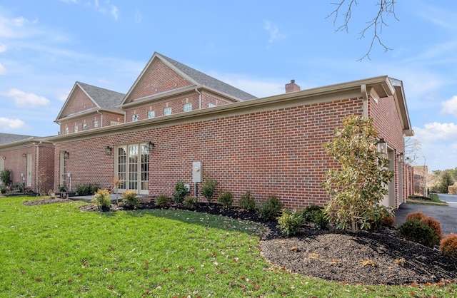 view of side of property with a garage and a lawn