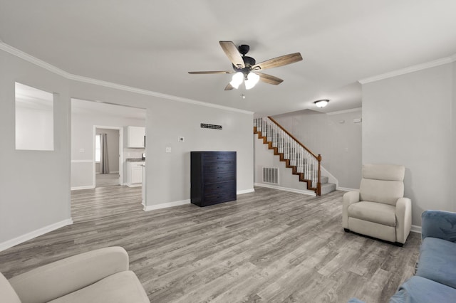 living room with crown molding, ceiling fan, and light hardwood / wood-style floors