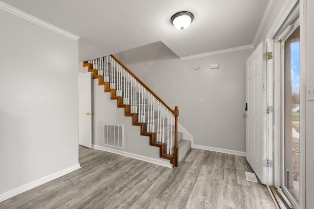 entryway featuring crown molding, light hardwood / wood-style flooring, and a healthy amount of sunlight