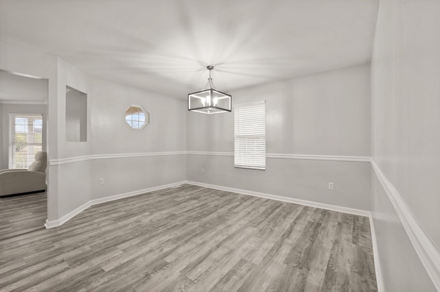 unfurnished dining area with light hardwood / wood-style flooring and an inviting chandelier