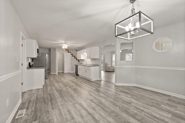 unfurnished living room featuring light wood-type flooring, ceiling fan, and sink