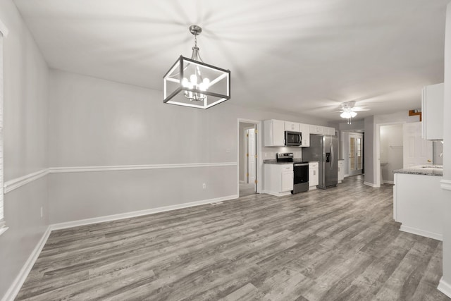 kitchen with ceiling fan with notable chandelier, light hardwood / wood-style flooring, appliances with stainless steel finishes, decorative light fixtures, and white cabinetry