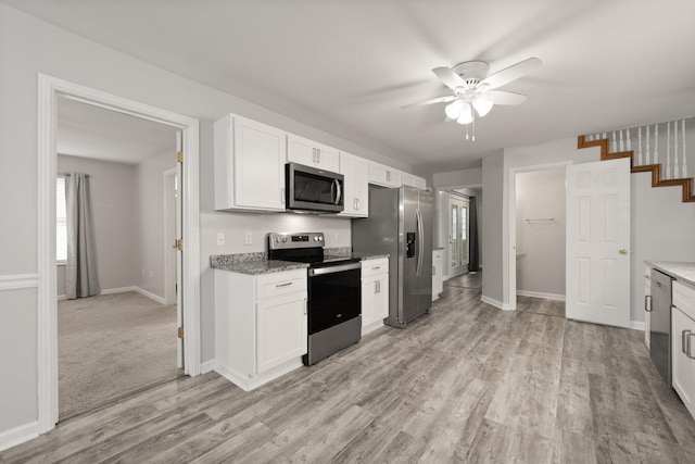 kitchen featuring ceiling fan, light wood-type flooring, white cabinetry, and stainless steel appliances