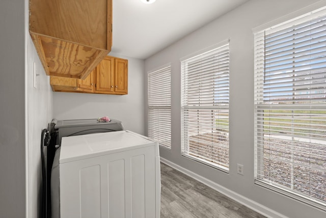 washroom with light hardwood / wood-style floors, cabinets, and independent washer and dryer