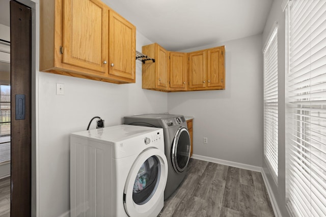 laundry room featuring washing machine and dryer, cabinets, and hardwood / wood-style flooring