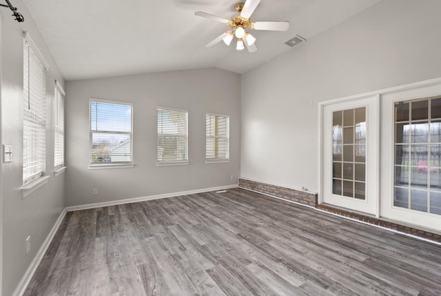 empty room with ceiling fan, hardwood / wood-style floors, and lofted ceiling