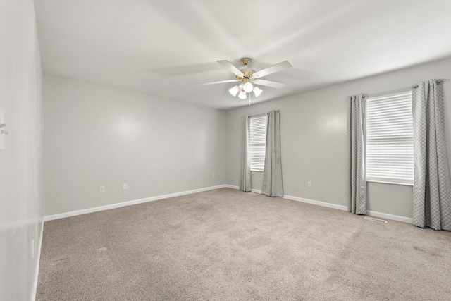 spare room with ceiling fan and light colored carpet