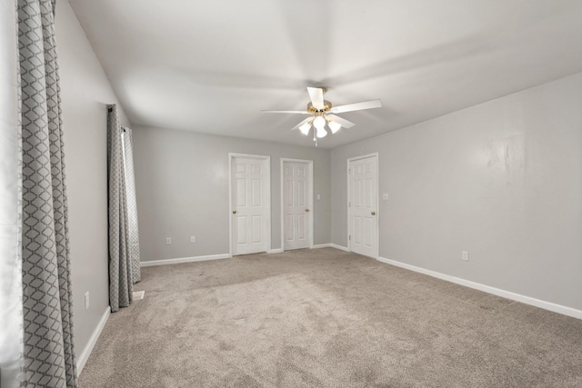 unfurnished bedroom with multiple closets, ceiling fan, and carpet floors