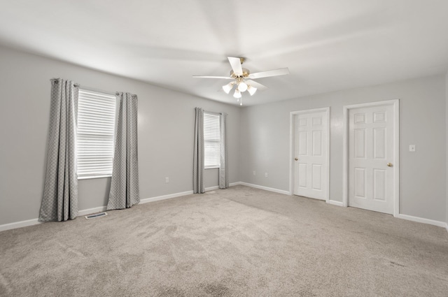 spare room featuring light carpet and ceiling fan